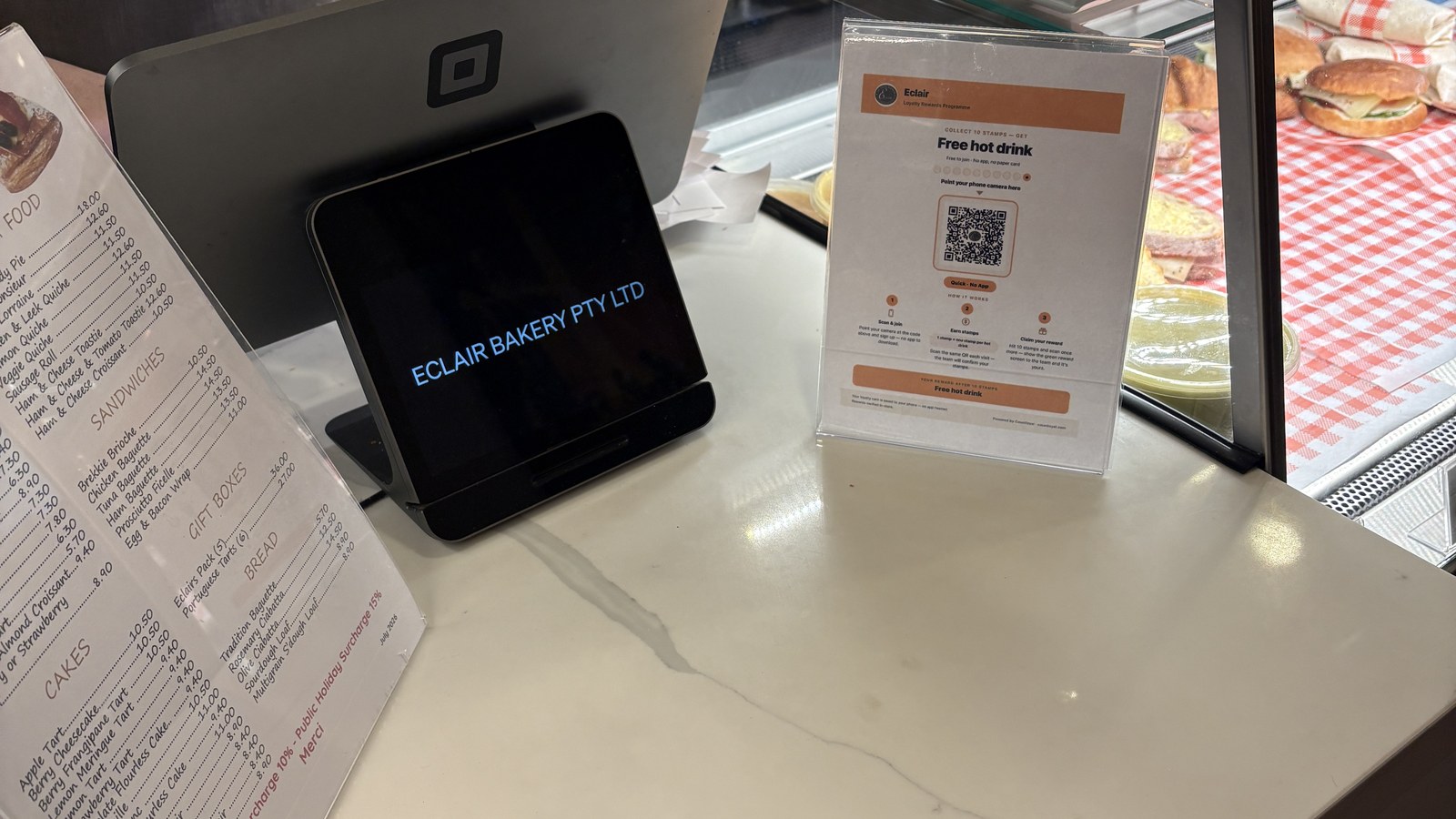 A Countloyal QR card in a holder beside the till at Éclair Boulangerie
