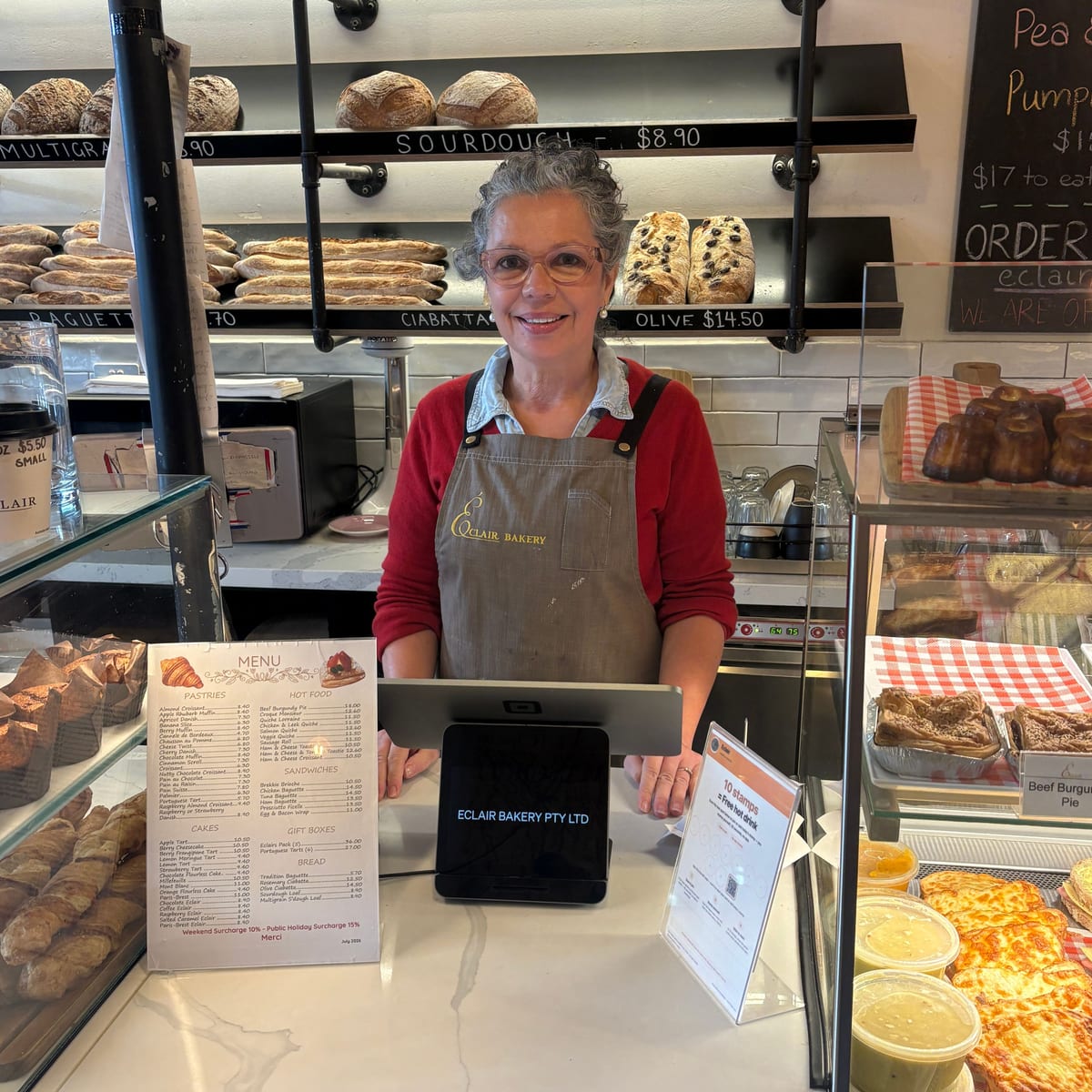 Patricia, owner of Éclair Boulangerie, behind her counter in Melbourne with the Countloyal card beside the till
